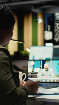 Vertical Video General manager meeting with the CEO on web teleconference after hours in the office, sharing data and insight for company transparency. Briefing late at night due to different time