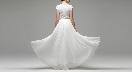 Fototapeta premium Elegant bride in a flowing white wedding dress twirling on a grey background