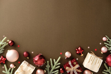 Elegant Christmas arrangement with ornaments, pine branches and gift boxes along bottom border on...