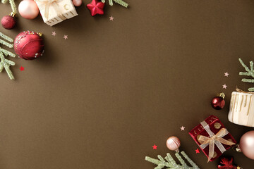 Christmas flat lay composition with ornaments, gift boxes and ribbon on brown background, leaving...
