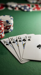 Royal Flush Poker Hand with Chips on Green Felt Table.