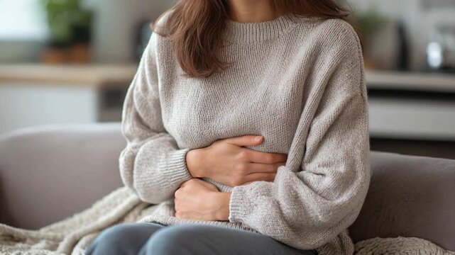 Woman suffering from irritable bowel syndrome holding her belly