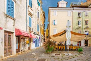 Fototapeta premium A covered sidewalk cafe in a small square of the picturesque old town district of the seaside town of Piran, Slovenia, in the Istria region along the Adriatic Sea.