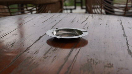 an aluminum cigarette ashtray is on the table