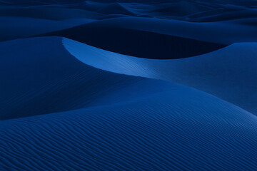 blue-hour desert scene, where subtle light reveals intricate dune patterns