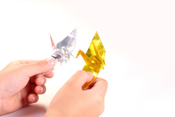 折り鶴を持つ子どもの手