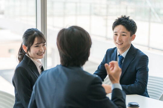Businessmen and women chatting in the office break space
