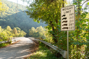 Weight limit up to 33t trucks over a steel bridge river gorge crossing in rural americas state roads and highway interstate system of infrastructure.