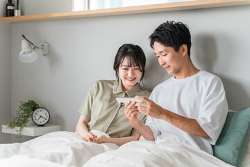 Obraz premium Asian couple, couple, lover, family using smartphone in bedroom