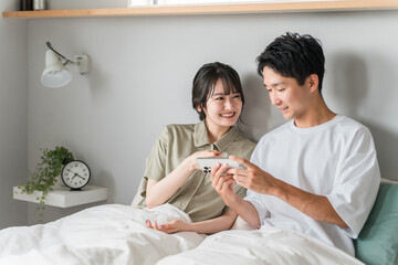Obraz premium Asian couple, couple, lover, family using smartphone in bedroom