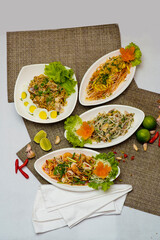 Assorted Thai Spicy Salads and Noodle Dishes on White Background