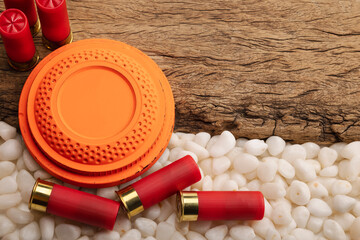 Clay disc flying targets and shotgun bullets on wooden background ,Clay Pigeon target