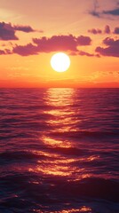 Vibrant sunset over a calm ocean with golden light reflecting on the rippling water and colorful clouds in the sky creating a serene and beautiful natural landscape