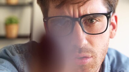 Closeup of young man with suspicious look touching camera lens like a digital button, showing curiosity and doubt, concept of technology, uncertainty, and virtual interaction.
 - Powered by Adobe