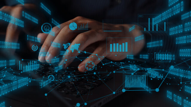 A modern workspace featuring hands typing on a laptop keyboard, surrounded by floating digital graphs and numbers, highlighting the dynamic world of data and technology. Xenic - Powered by Adobe