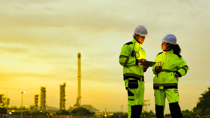 Witness the immense scale of petrochemical giants. Two engineers observe the sprawling industrial...