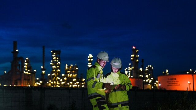 Energy professionals ensure continuous 24/7 operations at a refinery. The team uses digital technology to monitor sustainable production during the night shift.