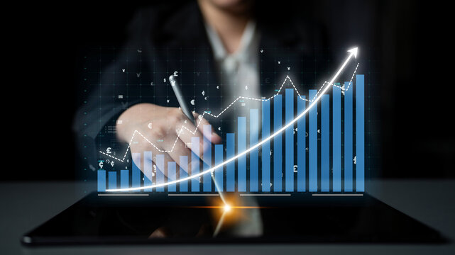 A business professional engages in financial analysis using a tablet, showcasing digital graphs and charts to illustrate growth trends and market insights. Impute - Powered by Adobe