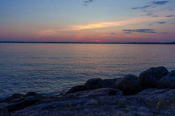 Fototapeta premium Industrial port view at sunset from rocky shore in Vyborg, Russia