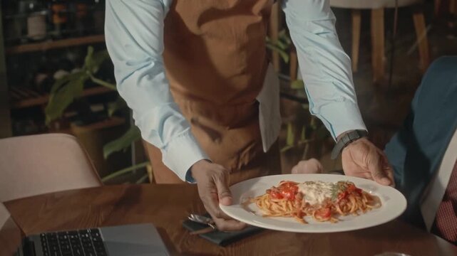 Elegant Waiter Serving Pasta in Fine Dining