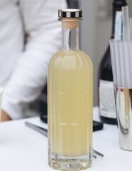 Barman mixing liquor beverages and alcohol drinks in plastic cups, bartender working, beautiful row line of different coloured cocktails on open air summer party in a bar, catering on banquet event