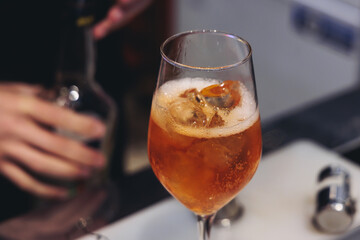 Barman mixing liquor beverages and alcohol drinks in plastic cups, bartender working, beautiful row line of different coloured cocktails on open air summer party in a bar, catering on banquet event