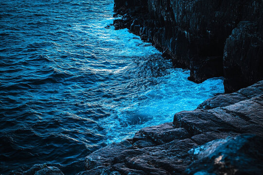 Bright blue waves illuminating the rocky coastline of a Nordic fjord   - Powered by Adobe