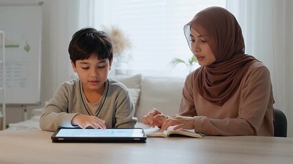 A woman and a young boy study together at a table, using a tablet and a book in a bright, cozy home setting. - Powered by Adobe