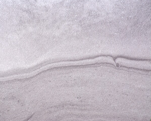 Gray marble, wavy natural stone pattern with inclusions, close-up.