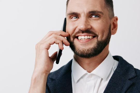 A confident business professional man on an isolated colored background, smiling while talking on a smartphone, conveying friendly productivity, focus, and approachable leadership in a corporate