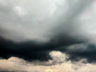 Dark, ominous storm clouds dominate the sky, with varying shades of gray and black. 
