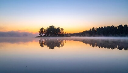 Fototapeta premium Serene Lake Reflection At Sunrise With Misty Island And Golden Sky Hues