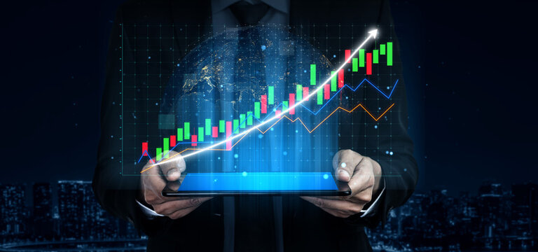 A businessman stands holding a tablet displaying dynamic financial graphs and data visualizations against a vibrant night cityscape, symbolizing growth and opportunity. Impute