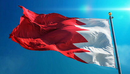 Bahrain's vibrant national flag waves proudly against a crystal clear blue sky, a symbol of freedom, unity, and national pride on a bright sunny day