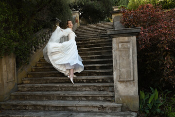 portrait of beautiful young blonde model wearing historical white wedding gown and fantasy cloak....