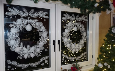 Elegant white christmas wreath decals adorn modern window glass