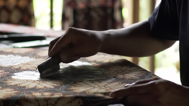 Detailed demonstration of traditional batik art creation with hot wax application process at its