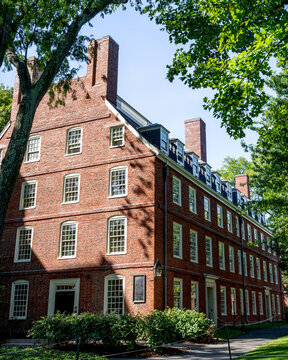 The Massachusetts Hall on Harvard University surrounded by trees under blue sky