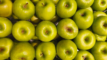 Stacks of fresh green apples in the grocery store, crisp and fresh fruit symbolizes freshness, health, and nutrition, perfect for diets, vegetarian lifestyles, and natural organic products.