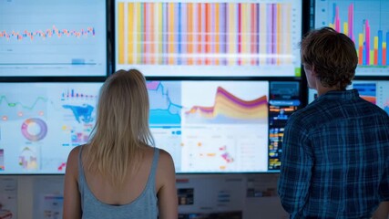 Advertising experts reviewing TV commercial performance analytics on a digital dashboard to enhance viewer targeting effectiveness.