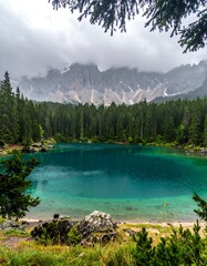 Serene turquoise lake nestled among towering evergreen trees and mountains