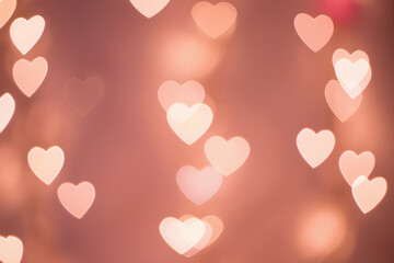Heart-shaped bokeh lights glowing on a warm blurred background, romantic soft-focus aesthetic. Generative AI