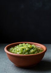 A vibrant, zesty tomatillo salsa in a rustic bowl, showcasing its fresh green hue and chunky texture. Perfect for dipping ,tomatillo ,condiment ,dip