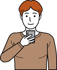 正面向き。スマホを見るTシャツの若い男性。