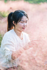 Woman enjoying the pink muhly grass in a field
