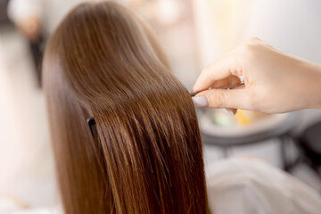 Fototapeta premium Female getting straight hair treatment at haircare salon