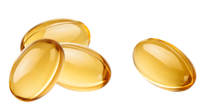close-up photograph of four golden yellow translucent gel capsules, likely containing omega 3 or fish oil, highlighted against a transparent background.