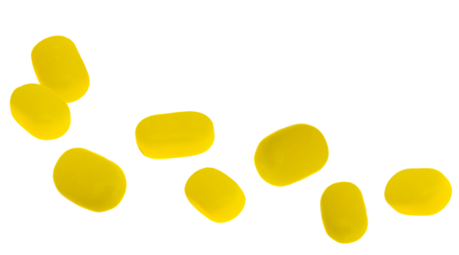 scattered arrangement of eight vibrant yellow, rounded, uncoated tablets, resembling natural dietary supplements or lozenges, isolated on a transparent background.