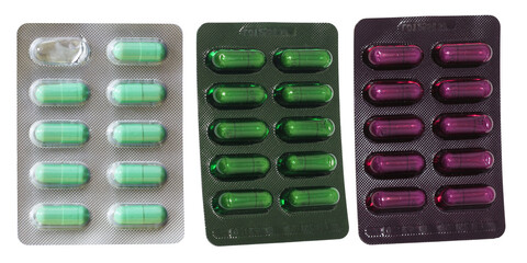 pharmaceutical photograph of three blister strips displaying large, colored capsules arranged side-by-side, including green and purple varieties, isolated on a transparent background.