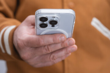 Close-up of a man hand holding a modern smartphone with a transparent case. Technology concept symbolizing digital communication, connection and mobile innovation.